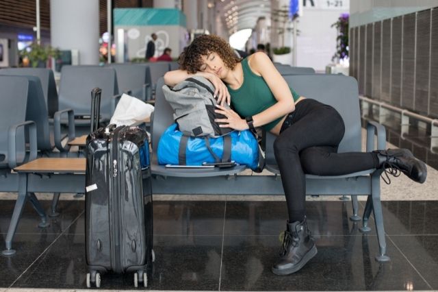 mochilero durmiendo en el aeropuerto