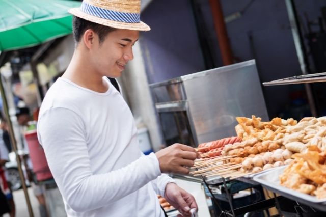 mochilero en un puesto de comida callejera en asia