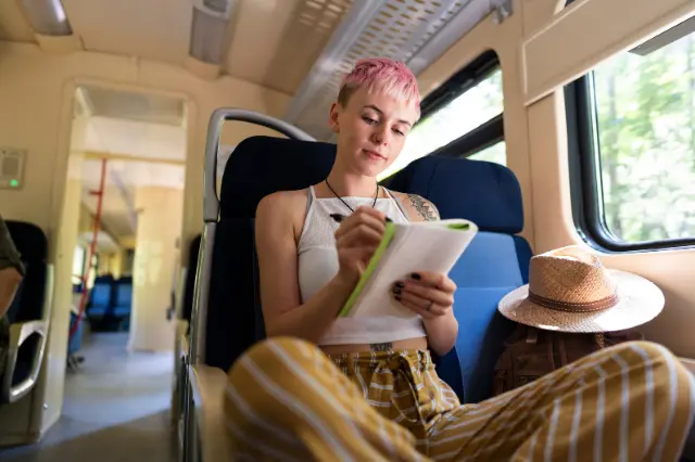 viajera escribiendo un diario de viaje en un tren